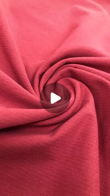 Reel cover: close-up swirl of red cotton-touch knitted fabric